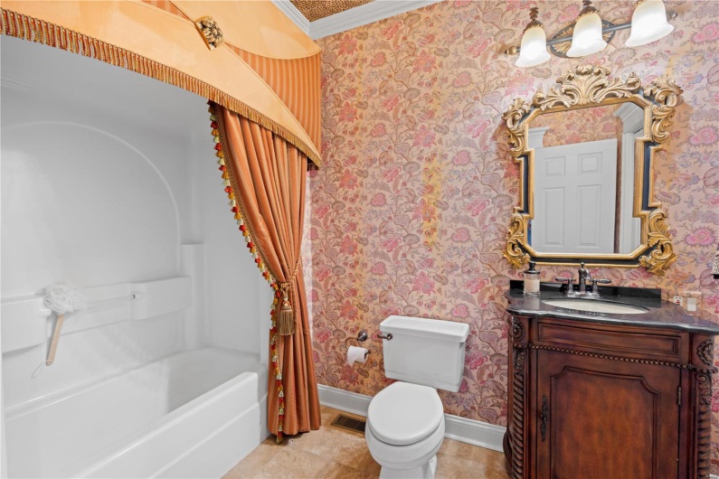 Full bathroom featuring shower / bath combo, tile patterned floors, ornamental molding, vanity, and toilet