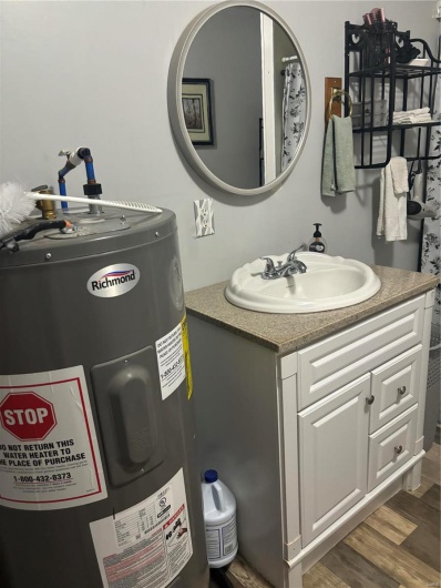 Bathroom featuring water heater, vanity, and hardwood / wood-style flooring
