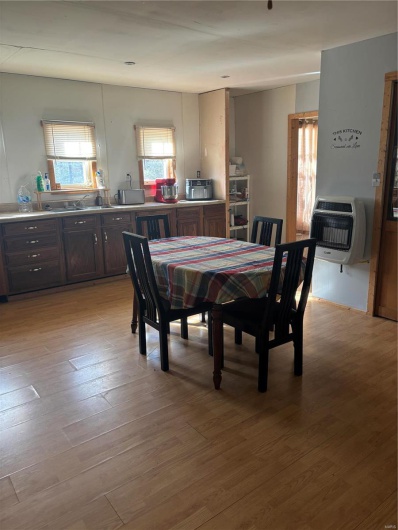 Dining space with heating unit and light hardwood / wood-style floors
