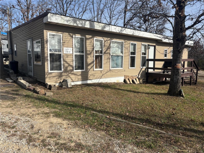 Exterior space with a wooden deck and a yard