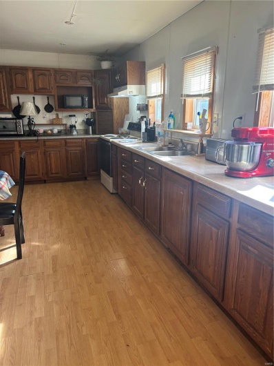 Kitchen with stainless steel range, light hardwood / wood-style flooring, and a healthy amount of sunlight