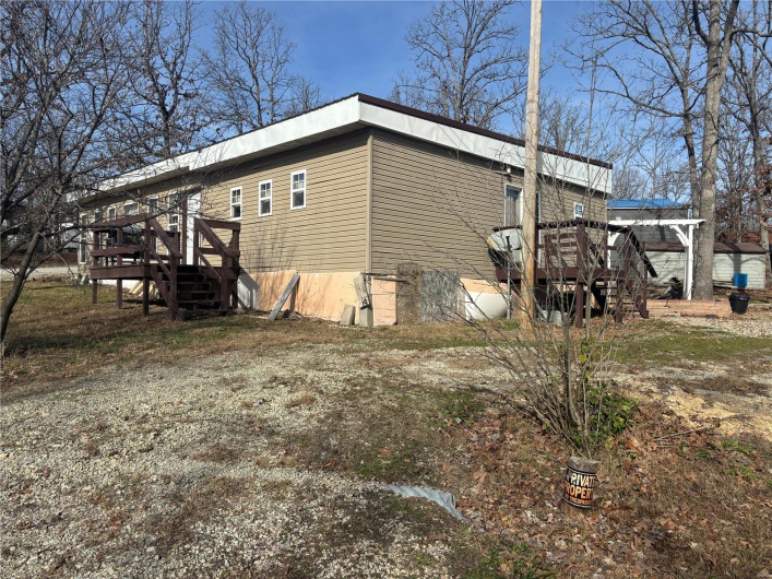 View of side of home with a wooden deck