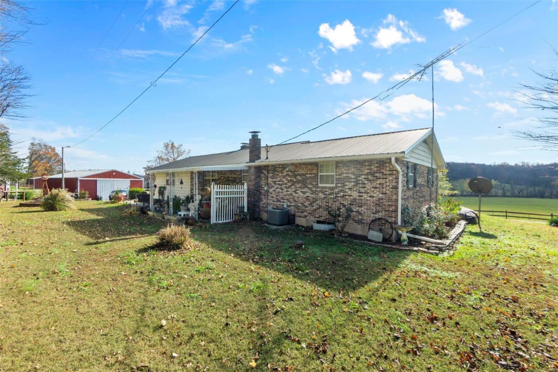 Rear view of property with cooling unit and a yard