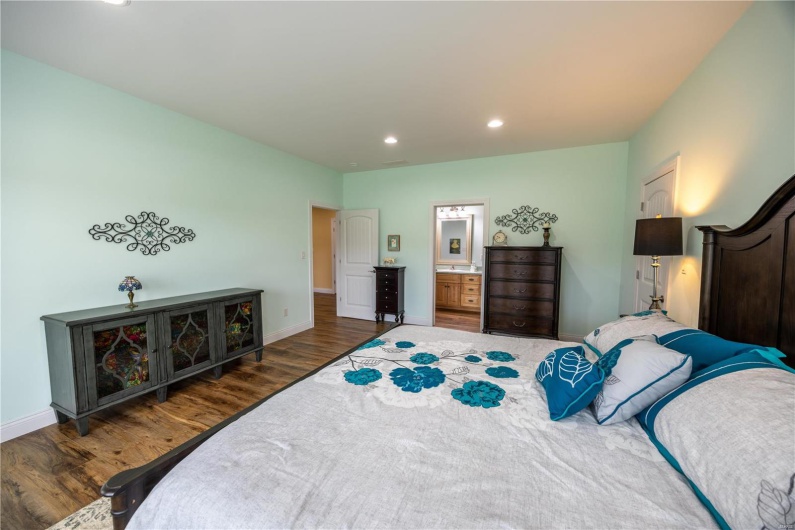 Bedroom featuring connected bathroom and LVP flooring.