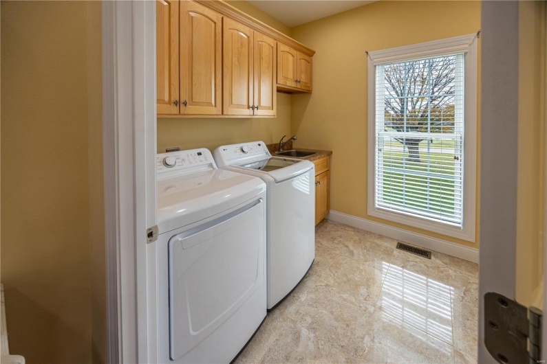 Laundry with cabinets and sink.