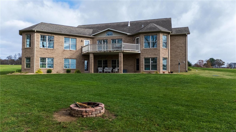Rear view of house with an outdoor fire pit, and wooden deck.