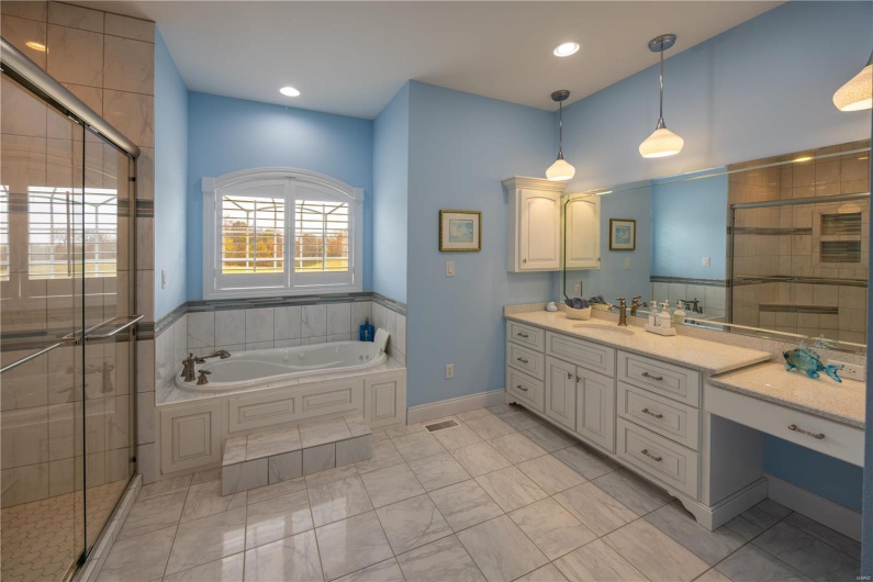 Bathroom with vanity, shower and separate bathtub.