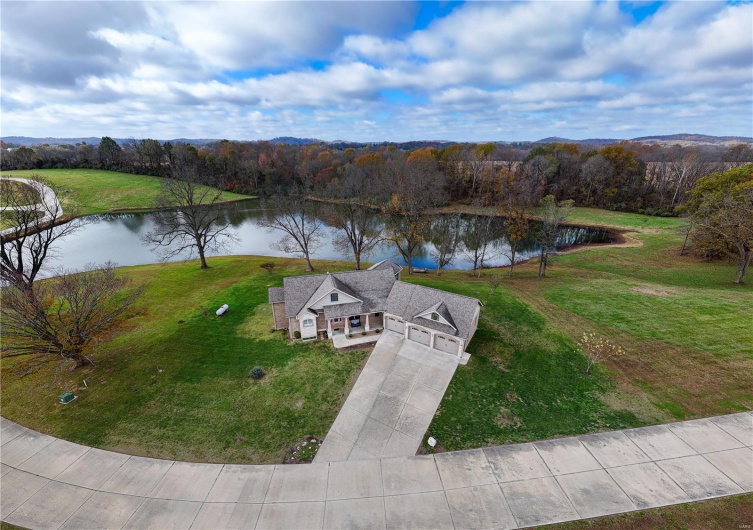 Aerial view featuring house with view of lake.