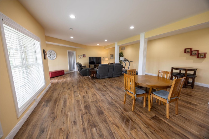 Family/rec room with LVP flooring, and view of lake in backyard.