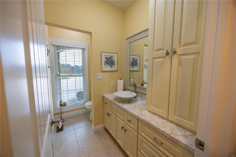 Bathroom featuring marble patterned flooring, vanity, and toilet.