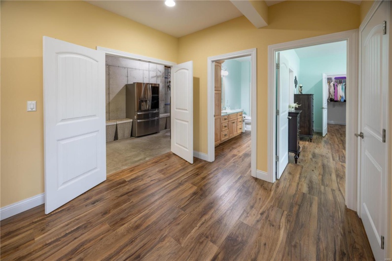 Opening to unfinished area and second laundry, with entry to bath & bedroom in lower level and LVP flooring.