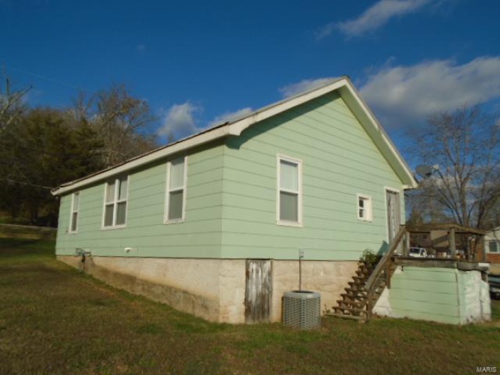View of home's exterior featuring a lawn and central AC unit
