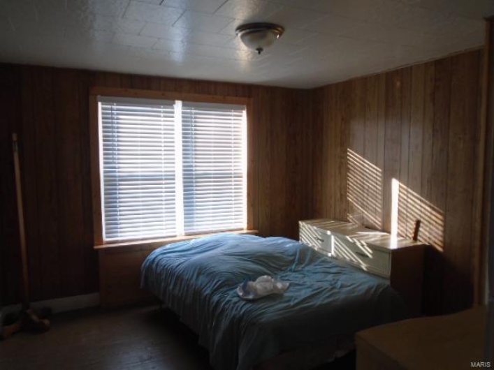 Bedroom featuring wood walls