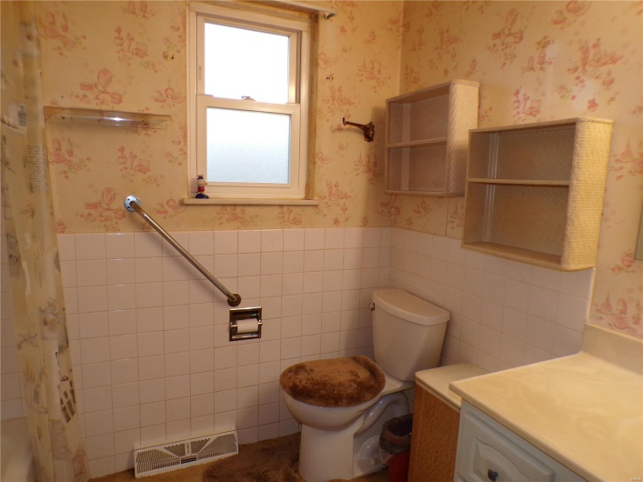Bathroom with vanity, toilet, tile walls, and walk in shower