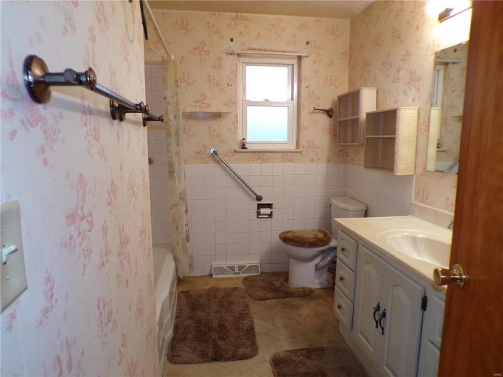 Full bathroom with vanity, bathing tub / shower combination, toilet, and tile walls