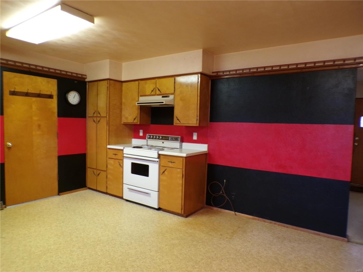 Kitchen features white range with electric stovetop as well as room for refrigerator and hutch, etc.