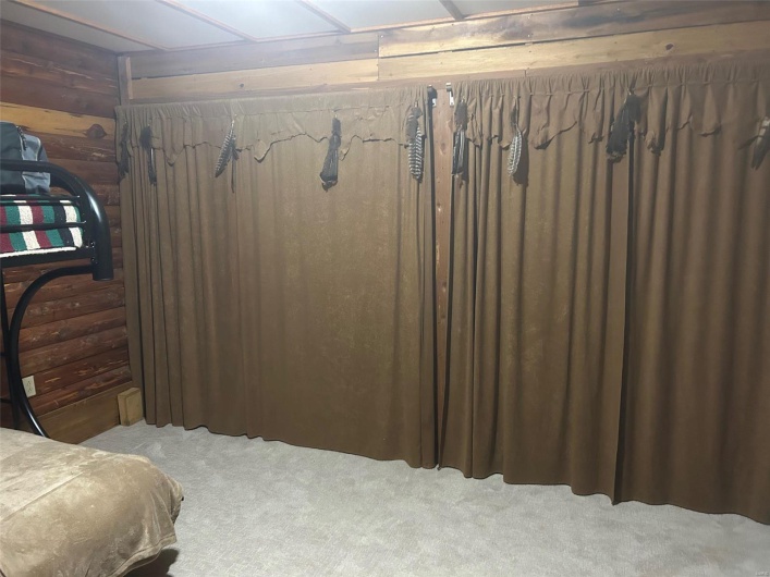 Bedroom featuring wooden walls and carpet