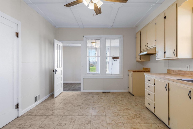 Kitchen featuring ceiling fan, sink, and cream cabinets