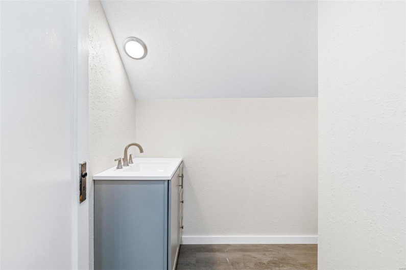 Bathroom with vanity and lofted ceiling