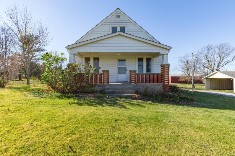 View of front of home with a front lawn and covered porch