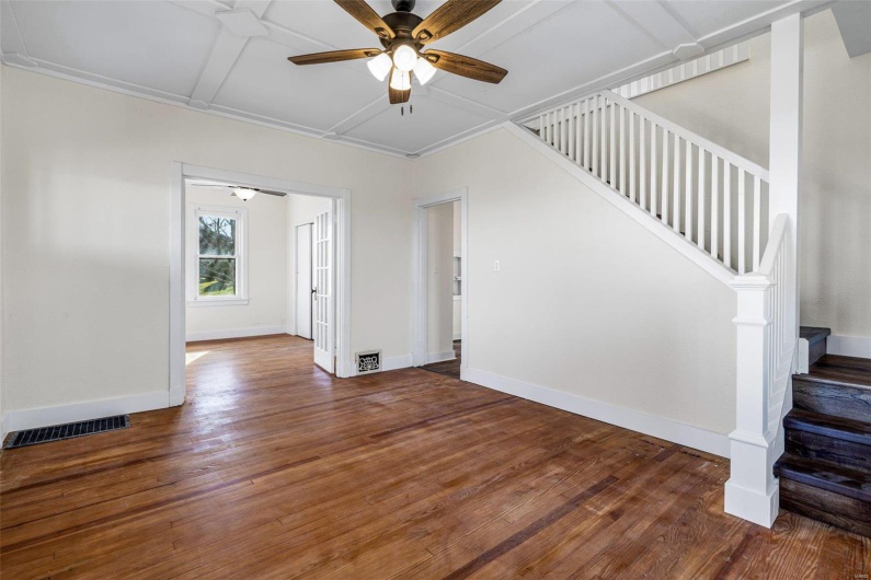 Unfurnished living room with ceiling fan and dark wood-type flooring