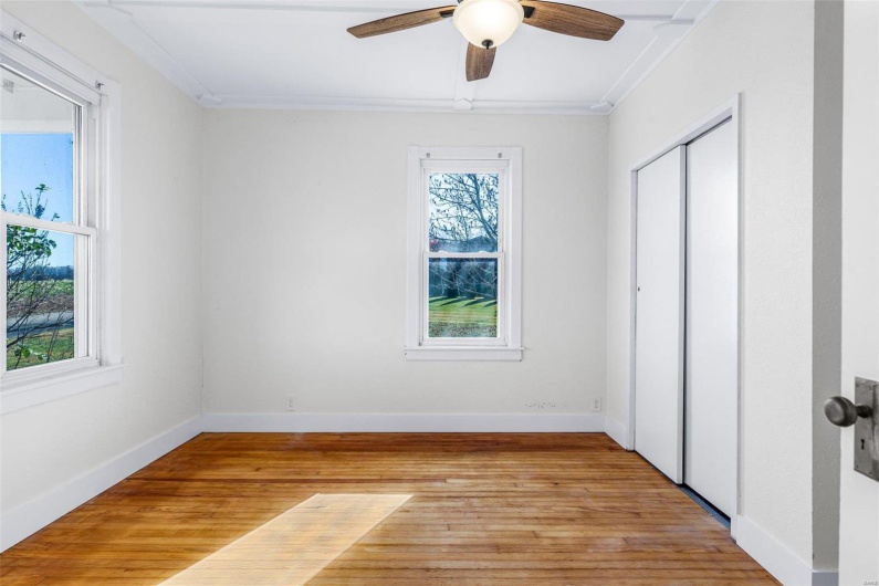 Unfurnished bedroom with ceiling fan, light wood-type flooring, crown molding, and a closet