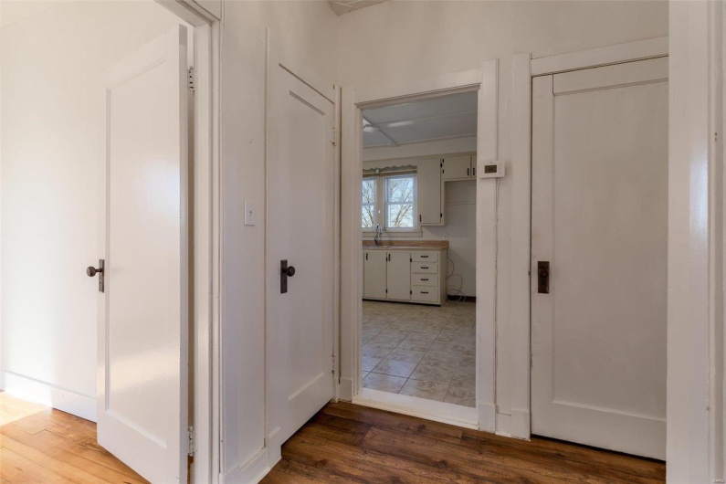 Corridor with hardwood / wood-style flooring and sink