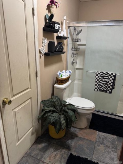 Bathroom with a shower with shower door and toilet