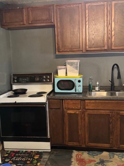 Kitchen featuring white appliances and sink