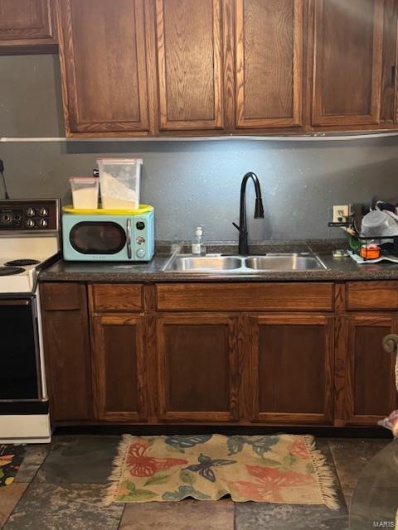 Kitchen featuring white appliances and sink