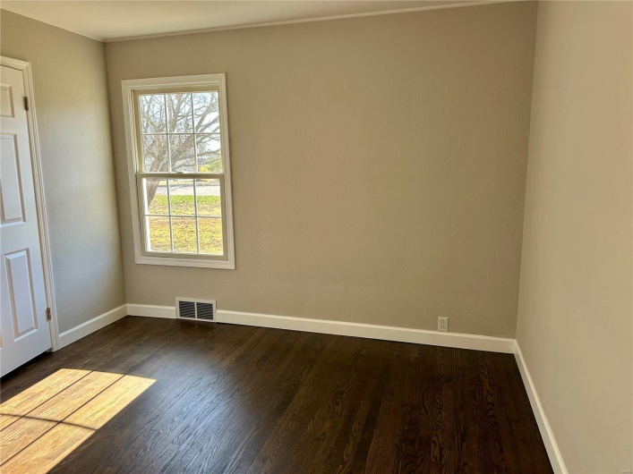 Empty room featuring dark wood-type flooring