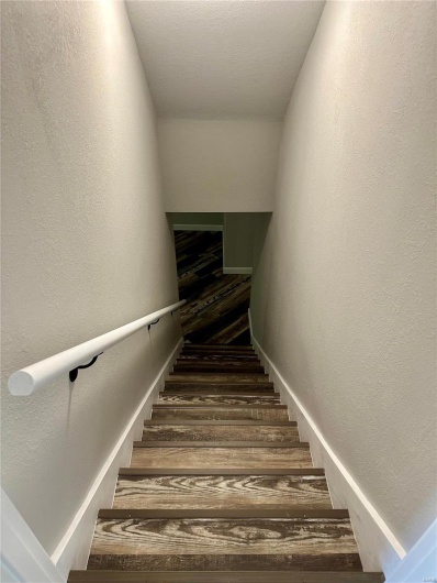 Stairway featuring hardwood / wood-style floors