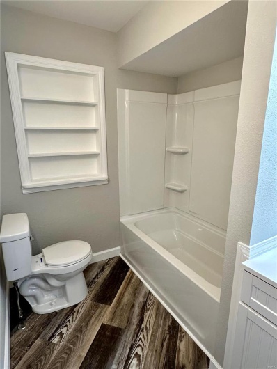 Full bathroom with hardwood / wood-style flooring, vanity, toilet, and shower / tub combination