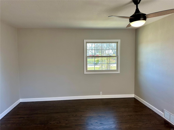 Unfurnished room with ceiling fan and dark hardwood / wood-style flooring