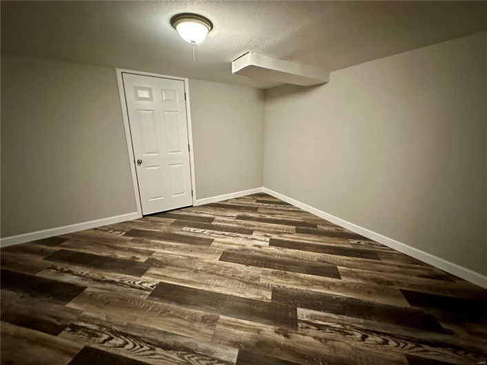 Basement with dark wood-type flooring