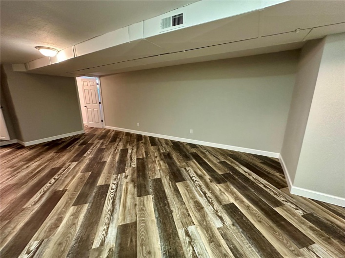 Basement with dark wood-type flooring