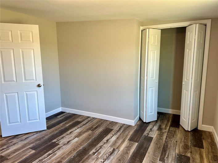 Unfurnished bedroom with a closet and dark wood-type flooring
