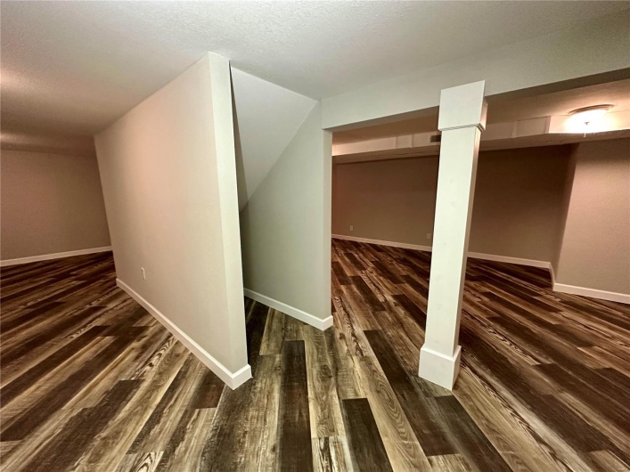 Hall with a textured ceiling and dark hardwood / wood-style floors