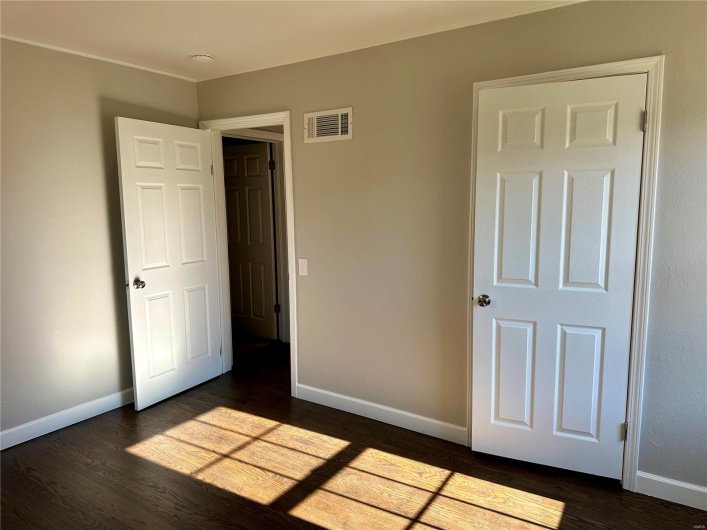 Unfurnished bedroom with dark hardwood / wood-style flooring