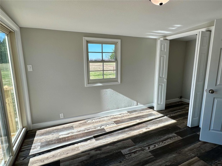Unfurnished bedroom featuring a closet and dark hardwood / wood-style floors