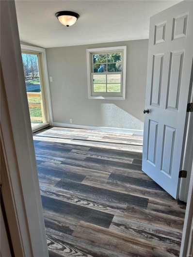 Spare room featuring dark hardwood / wood-style floors and a healthy amount of sunlight
