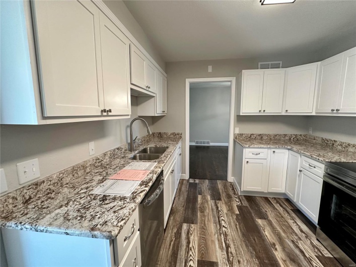 Kitchen featuring white cabinetry, sink, and stainless steel appliances