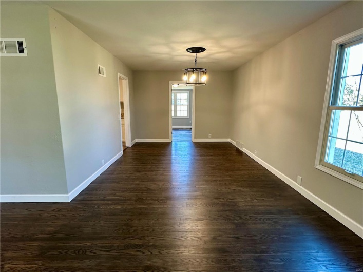Unfurnished dining area with dark hardwood / wood-style flooring and a chandelier