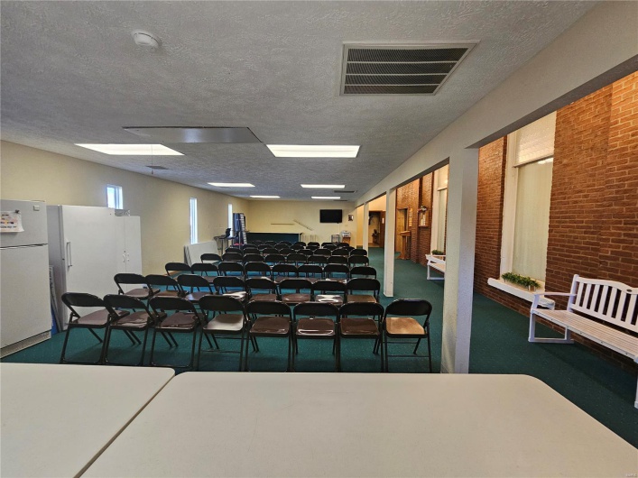Interior space featuring a textured ceiling and brick wall