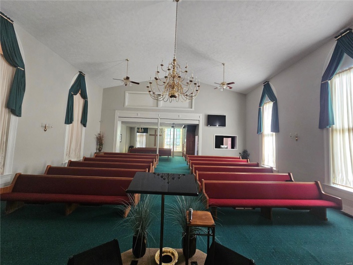 Miscellaneous room with carpet flooring, ceiling fan with notable chandelier, a textured ceiling, and vaulted ceiling