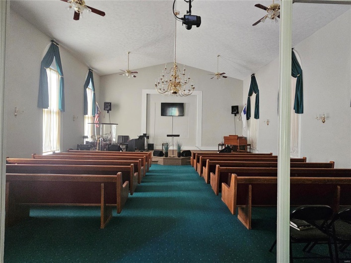 Miscellaneous room with carpet floors, vaulted ceiling, and a notable chandelier