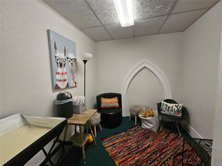 Sitting room with a drop ceiling and carpet floors