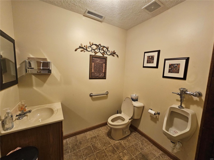 Bathroom featuring vanity, toilet, and a textured ceiling