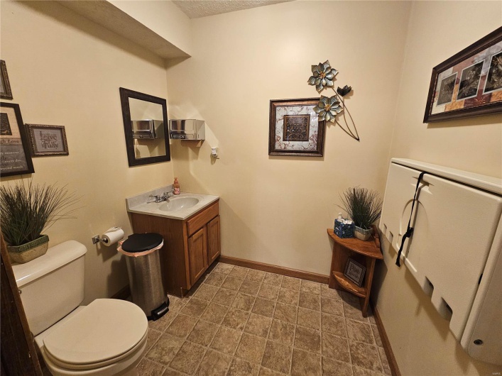 Bathroom featuring vanity, a textured ceiling, and toilet