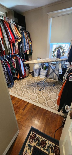 Walk in closet with wood-type flooring